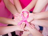 women show pink ribbon with breast cancer prevention on the pink background